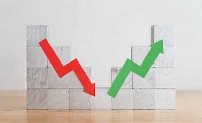 Roter Abwärtspfeil und grüner Aufwärtspfeil auf Holzblöcken