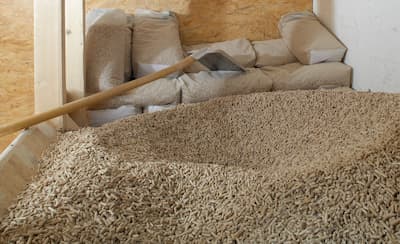 Lagerraum mit Holzpellets und Schaufel, im Hintergrund Pellet-Säcke